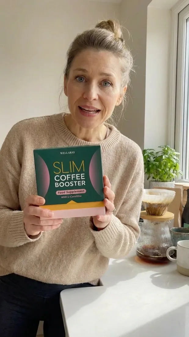 Frau zeigt die Wellaray Slim Coffee Booster Box in ihrer Küche neben frisch gebrühtem Filterkaffee